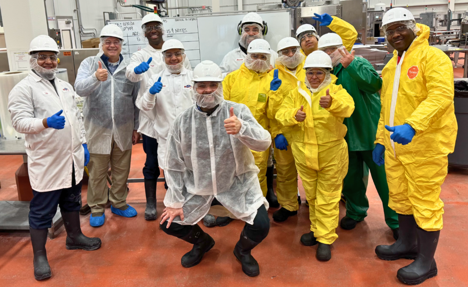 Sanitation team smiling and holding thumbs up