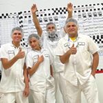 Four Harrigan Sanitation Solutions team members in white uniforms and hairnets giving thumbs up